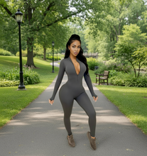 Load image into Gallery viewer, Woman in a gray jumpsuit walking on a path in a park
